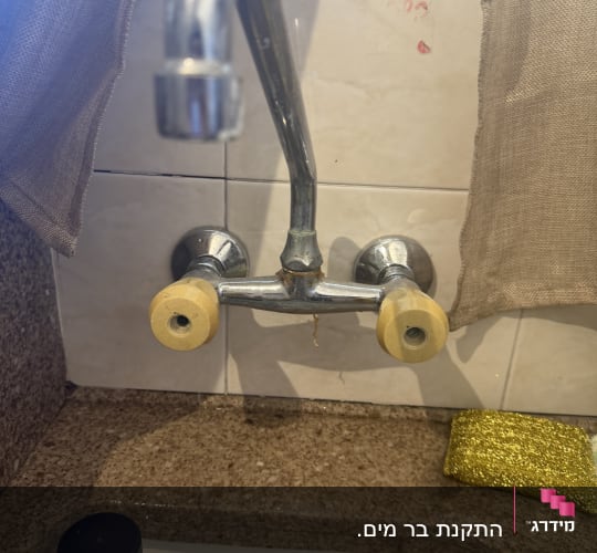 ברז מטבח עם ידיות צהובות וספוג ניקוי